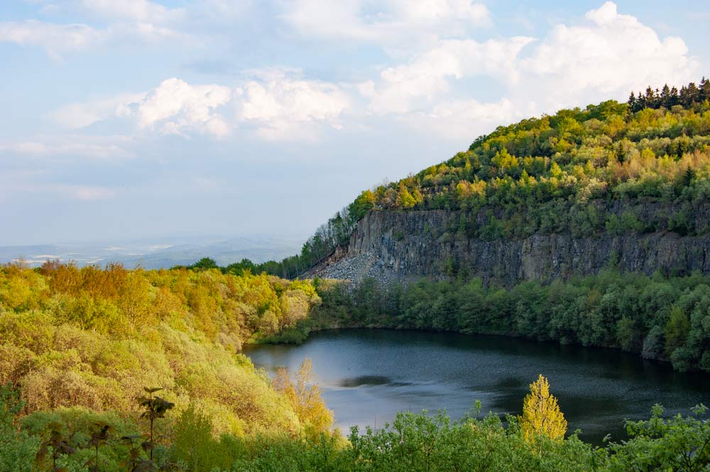 Bergsee im Talkessel am Hohen Meißner – Felswände, Wald und weite Hügellandschaft.
