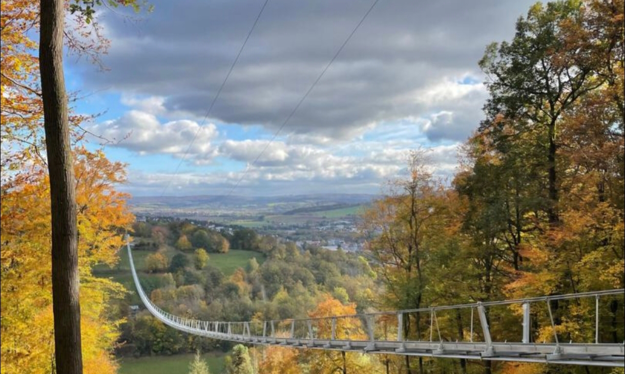 Die Hängeseilbrücke Highwalk über einem herbstlich gefärbten Tal.